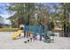 A colorful playground featuring a slide, bridge, and climbing structures, with a sand base and wooded backdrop at 7896 Montview Rd, North Charleston, SC 29418