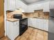 Functional kitchen featuring white cabinetry, tile countertops, and modern black appliances at 7914 Dutch Ct, North Charleston, SC 29420