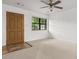 Clean, neutral living room featuring plush carpet, a new ceiling fan, and fresh white walls at 7914 Dutch Ct, North Charleston, SC 29420