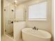 Luxurious bathroom featuring a soaking tub, a glass-enclosed shower, and modern fixtures at 8633 Connor Ct, North Charleston, SC 29406