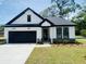 Charming single-story home with a black garage door, stone accents, and manicured landscaping at 8633 Connor Ct, North Charleston, SC 29406