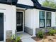 Close-up of a modern front door with stone accents, black trim, and manicured landscaping at 8633 Connor Ct, North Charleston, SC 29406