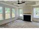 Bright living room featuring a fireplace, a tray ceiling with ceiling fan, and large windows at 8633 Connor Ct, North Charleston, SC 29406