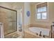 Bright bathroom features a tile shower, jacuzzi tub, and natural light at 8657 Refuge Point Circle Cir, Charleston, SC 29420