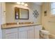 Bathroom featuring granite counters, white cabinets, decorative mirror, and modern fixtures at 8657 Refuge Point Circle Cir, Charleston, SC 29420