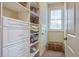 Walk in closet featuring built in shelving, drawers, and a window for natural light at 8657 Refuge Point Circle Cir, Charleston, SC 29420
