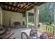 Relaxing covered patio with stone pavers, comfortable seating, and a view of the lush backyard at 8657 Refuge Point Circle Cir, Charleston, SC 29420