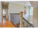 Upstairs hallway features hardwood floors, iron railings, and a beautiful chandelier at 8657 Refuge Point Circle Cir, Charleston, SC 29420