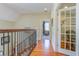 Upstairs hallway features hardwood floors, iron railings, and lots of natural light at 8657 Refuge Point Circle Cir, Charleston, SC 29420