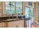 Kitchen sink with granite countertops and a view to the screened back porch at 8657 Refuge Point Circle Cir, Charleston, SC 29420