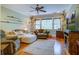 Spacious living room with wood floors, a ceiling fan, and multiple windows offering natural light at 8657 Refuge Point Circle Cir, Charleston, SC 29420