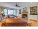 Cozy living room with a fireplace, ceiling fan, built-in shelving and wood flooring at 8657 Refuge Point Circle Cir, Charleston, SC 29420