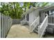 Exterior backyard view of a home with stairs to the back entrance, wooden fence, and lush green trees at 987 Harbor Oaks Dr, Charleston, SC 29412