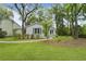 Charming home features a manicured lawn, mature trees, and a welcoming walkway leading to the front entrance at 987 Harbor Oaks Dr, Charleston, SC 29412
