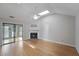 Bright living room offering a vaulted ceiling, skylight, wood floors, and a stone fireplace at 987 Harbor Oaks Dr, Charleston, SC 29412