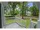 Cozy covered front porch with white railings offering a view of the well-maintained lawn and street at 987 Harbor Oaks Dr, Charleston, SC 29412