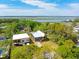 Gorgeous aerial view of a gray house featuring a metal roof surrounded by lush green trees and a serene waterway at 1014 E Erie Ave, Folly Beach, SC 29439