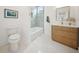 Bright bathroom features a tub with light blue tile surround and modern vanity with gold-trimmed mirror at 1014 E Erie Ave, Folly Beach, SC 29439