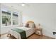 Bright bedroom features hardwood floors, neutral decor, and a large window overlooking lush greenery at 1014 E Erie Ave, Folly Beach, SC 29439