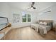 Bright bedroom featuring a ceiling fan, hardwood floors, and a large window overlooking the outdoors at 1014 E Erie Ave, Folly Beach, SC 29439