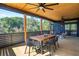 Spacious screened deck with outdoor dining area, comfortable seating, and a serene backyard view at 1014 E Erie Ave, Folly Beach, SC 29439