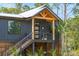 Exterior view of home featuring dark gray siding, wood-finished posts and stairs, and metal cable railing at 1014 E Erie Ave, Folly Beach, SC 29439