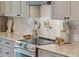 Close-up of the kitchen with a mosaic backsplash, stainless steel range, and stylish countertop decor at 1014 E Erie Ave, Folly Beach, SC 29439