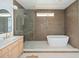 Sleek main bathroom features a single vanity, a glass-enclosed shower, and a soaking tub at 1014 E Erie Ave, Folly Beach, SC 29439