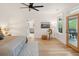 Bright main bedroom featuring a ceiling fan, light hardwood floors, and a glass door to the outdoor patio at 1014 E Erie Ave, Folly Beach, SC 29439