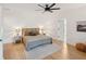 Bright main bedroom featuring a ceiling fan, a large bed with woven headboard, and light hardwood floors at 1014 E Erie Ave, Folly Beach, SC 29439