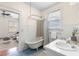 Bright bathroom featuring a clawfoot tub, tiled floors, and a view into the living room at 103 Tall Oak Ave, Charleston, SC 29407