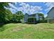 A blue home with a screened porch, shed, and large green backyard surrounded by a wood fence at 106 Trimley Ct, Goose Creek, SC 29445