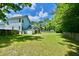 Spacious backyard featuring a light blue house, screened porch, shed, and plenty of green grass for outdoor activities at 106 Trimley Ct, Goose Creek, SC 29445