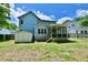 A blue home with a screened porch, shed, and wood stairs surrounded by grass and a clear blue sky at 106 Trimley Ct, Goose Creek, SC 29445