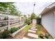 Landscaped backyard featuring a stone pathway lined with flowerbeds and a charming garden gate at 107 Clear Bend Ln, Summerville, SC 29486