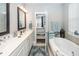 Bright bathroom featuring soaking tub, dual vanity, and ensuite access at 107 Clear Bend Ln, Summerville, SC 29486