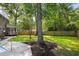 Spacious backyard featuring a large shade tree, fenced in yard, and partial pool view at 108 Old Dominion Dr, North Charleston, SC 29418