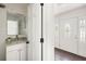 Stylish half bathroom featuring white cabinets, granite countertops, and a decorative mirror near the entry at 108 Old Dominion Dr, North Charleston, SC 29418