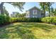 Spacious backyard featuring lush green lawn, mature trees, and a charming fence for privacy at 11 Franklin St, Charleston, SC 29401