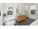 Bathroom featuring modern double sink, bathtub, walk-in shower, and unique black and white floors at 11 Franklin St, Charleston, SC 29401