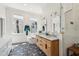 Bright bathroom with double sink vanity, soaking tub, walk in shower and stylish black and white patterned floors at 11 Franklin St, Charleston, SC 29401