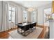 Bright dining room boasts modern chandelier, neutral rug, and natural light from the three large windows at 11 Franklin St, Charleston, SC 29401