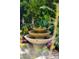 Elegant three-tiered water fountain surrounded by lush greenery and colorful flowering plants at 11 Franklin St, Charleston, SC 29401