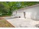 Backyard with a brick home, gray gravel, concrete patio, and trees at 1109 Hillside Dr, Charleston, SC 29407