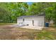 Backyard with a brick home, gray gravel, concrete patio, and trees at 1109 Hillside Dr, Charleston, SC 29407