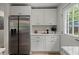Kitchen area with stainless steel refrigerator, white cabinets and a door to the backyard at 1109 Hillside Dr, Charleston, SC 29407