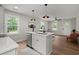 Open concept kitchen with a stainless steel dishwasher, an island with seating, and updated lighting at 1109 Hillside Dr, Charleston, SC 29407