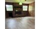 Living room featuring a brick fireplace with wood paneling and vinyl floors at 1130 Yeamans Hall Rd, Hanahan, SC 29410