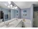 Bright bathroom features double sink vanity, separate shower, and soaking tub at 1136 Peninsula Cove Dr, Charleston, SC 29492
