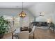 Bright dining area with a contemporary chandelier, wood floors, and comfortable seating adjacent to the living room at 1136 Peninsula Cove Dr, Charleston, SC 29492